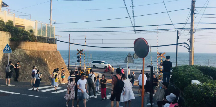 Khách du lịch chụp ảnh bên cạnh đường sắt băng qua gần trường trung học Kamakura xuất hiện trong bộ phim hoạt hình nổi tiếng của Nhật Bản “Slam Dunk” gây khó khăn cho các phương tiện di chuyển.